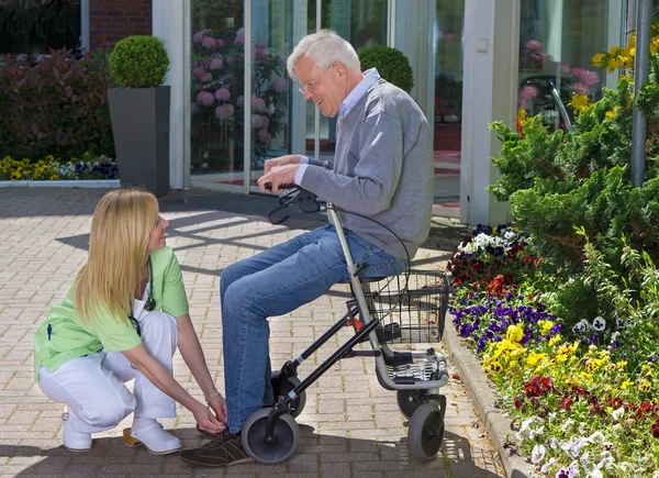 Sjuksköterskan att hjälpa äldre man — Stockfoto