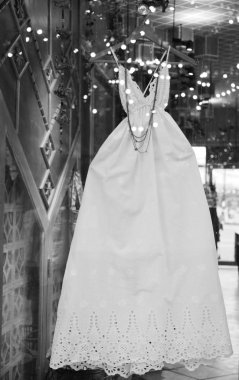 Beyaz kadın elbiseleri duvarda asılı.