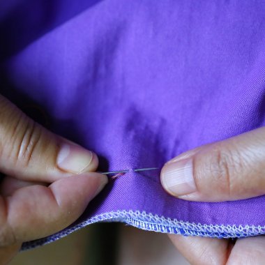 Yakın plan kadınlar, mor kumaş ve iğne dikiyorlar.