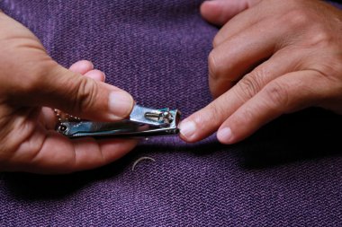 closeup of a man cutting nails