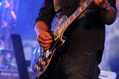 Konserde gitar çalan bulanık müzisyen