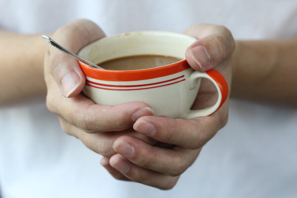 two hand hold warm coffee cup, closeup