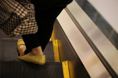 Yürüyen merdivende duran insanlar