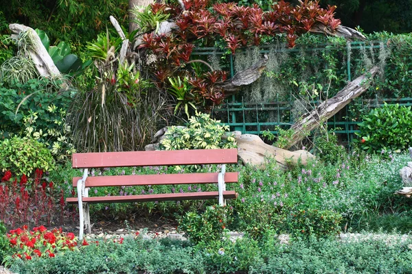 Коричневый стул в цветочном саду с пешеходной дорожкой — стоковое фото