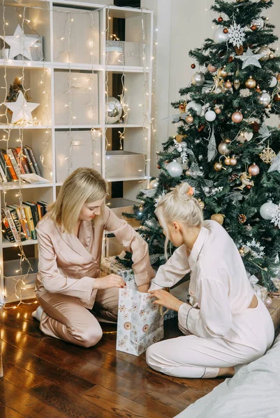 Women at home decorate the Christmas tree for the Christmas holidays, the concept of friendship and relationships. LGBT PERSON