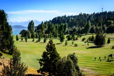 Öğleden sonra Bariloche 'deki golf sahasında. Yaz günü ve golf. Çamlar ve dağlar.