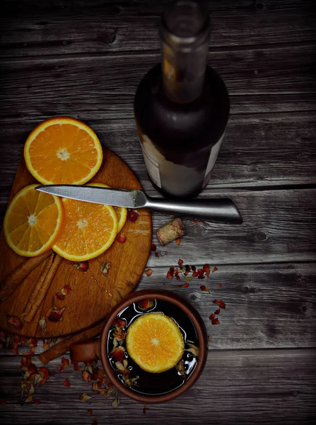 a cup of red mulled wine with sliced orange, cinnamon and dried rose petals