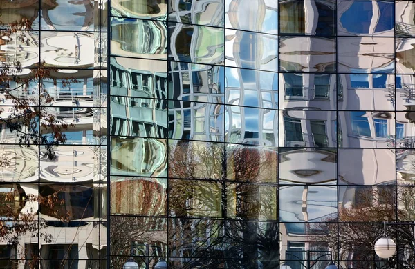 Glasfasad på modern kontorsbyggnad med suddiga reflektioner Stockbild