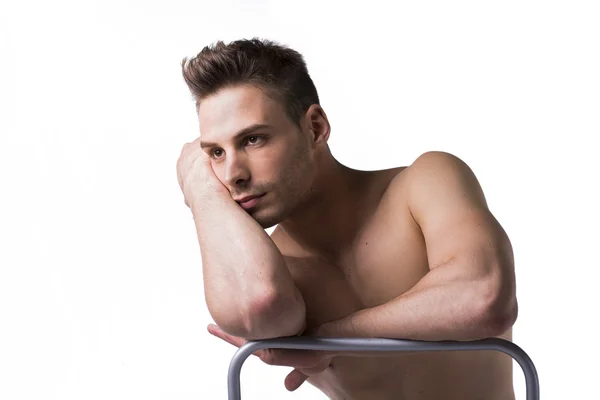 Naked young man sitting and resting on chair's back — Stock Photo, Image