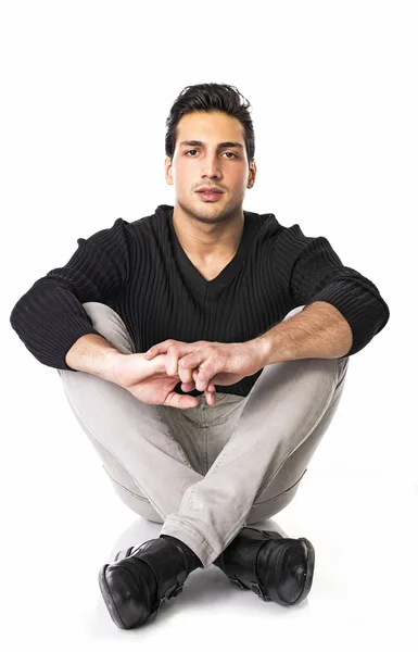 Good looking young man sitting with legs crossed — Stock Photo, Image