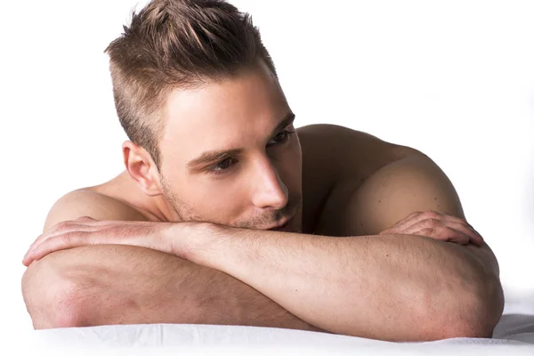 Cute expression, naked young man on white sheets — Stock Photo, Image