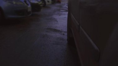 Çok kötü durumdaki bir yolda araba tekerleğini kapat. Çukur dolusu kirli su birikintisi var.