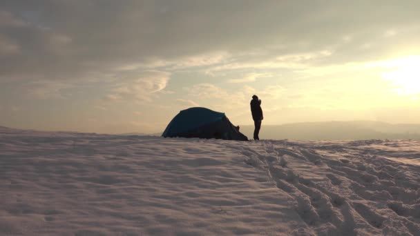 1日のハイキングの後 テントの前 雪の多い冬の山の中で 火山から熱いお茶をお楽しみください — ストック動画