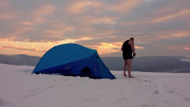 短時間のハイカーは テントの前 雪の多い冬の山の中で 一日のハイキングの後に魔法瓶から熱いお茶を楽しむ — ストック動画