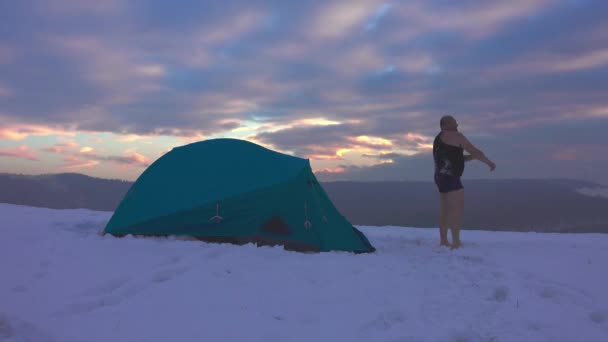 テントから出て 寒い天気を楽しみ 雪の多い冬の山の中でハイカー — ストック動画