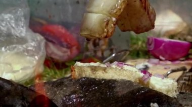 Yürüyüş yemeği. Doğal ateşte domuz pastırması ve sosis kızartıp yağları peynir ve soğanla üzerine damlatacağız.