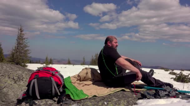 Yürüyüşçü Kar Üzerinde Bir Kayanın Üzerinde Uyku Tulumuna Giriyor Kış — Stok video