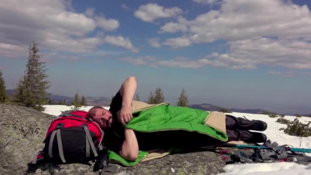 Yürüyüşçü Kar Üzerinde Bir Kayanın Üzerinde Uyku Tulumuna Giriyor Kış — Stok video