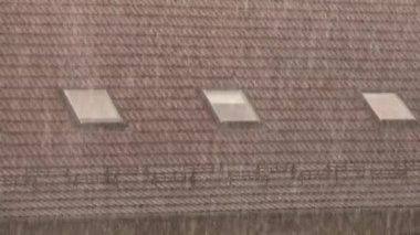Heavy rain pouring on a building roof