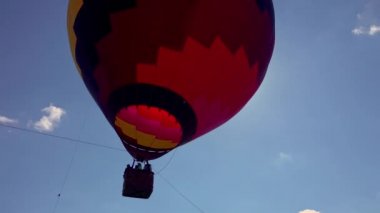 Sıcak hava balonu, bulutlu bir günde, gün batımından sonra kalkışa hazırlanıyor.