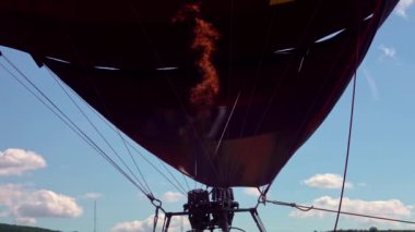 Sıcak hava balonu, bulutlu bir günde, gün batımından sonra kalkışa hazırlanıyor.