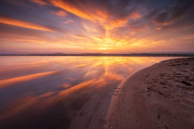 Güneşin doğuşunda kumsalda muhteşem bir manzara.