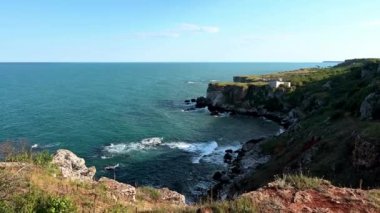 Telefonuyla fotoğraf çeken ve resimli kayalık sahil şeridinin keyfini çıkaran bir kızla drone videosu.. 