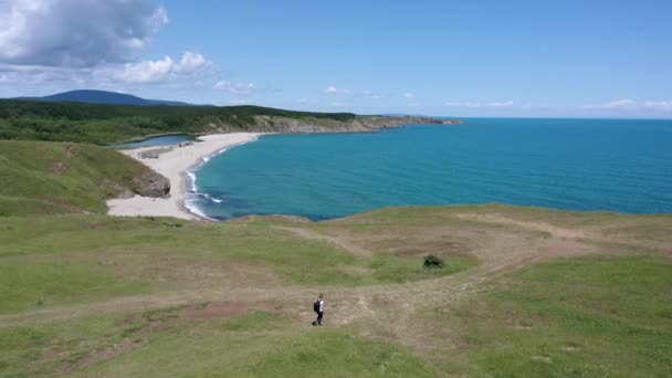 在保加利亚黑海南部海岸 一个背着背包的女人在绿油油 风景如画的海岸线上漫步 无人机在她上方盘旋 — 图库视频影像