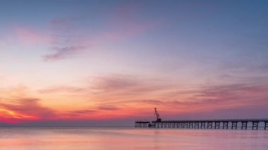 Gündoğumunda kumlu bir sahilin renkli yakın görüntüsüyle hızlandırılmış. Dramatik deniz gündoğumu, yumuşak pembe gökyüzü ve parlak dalgalar.