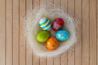 Paskalya konsepti. Ahşap arka planda renkli boyanmış Paskalya yumurtaları ile Paskalya süslemesi.