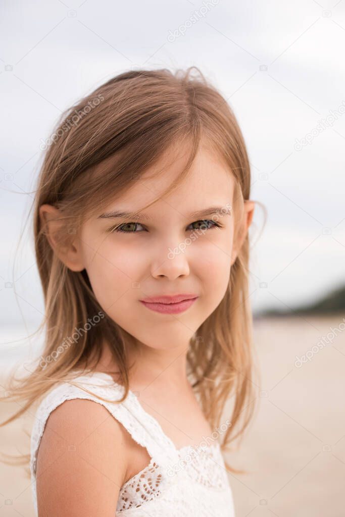 Close up portrait of cute little girl on the beach