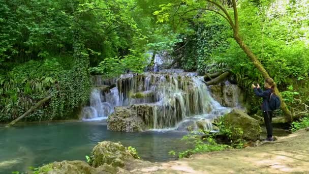 Video Girl Taking Pictures Enjoys Beautiful Waterfall Green Spring Forest — Stock videók