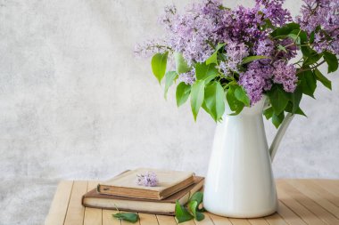 Sanatsal bir arka planda vazoda çiçek açan leylak çiçekleriyle dolu bir hayat.