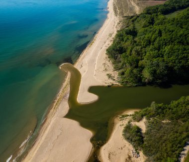 Kumlu bir sahil manzarası ve denize akan bir nehir, Bulgaristan 'ın Karadeniz kıyısındaki Kamchia Nehri' nin ağzı.