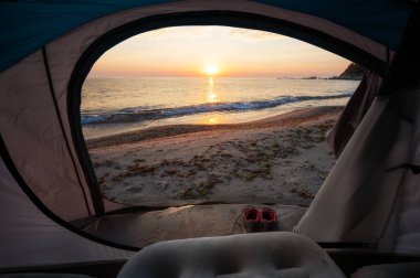 Çadırın içinden deniz doğumu manzarası