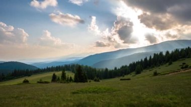 Gün batımında, ağaçlarla kaplı dağların tepesinde, Bulgaristan 'daki Rodoplar' ın güzel hareket eden bulutlarıyla birlikte zaman daralıyor.