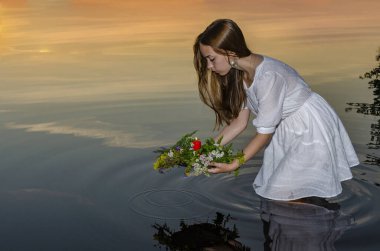 Kız eski Slav falcılık ayinini İvan Kupala bayramının arifesinde darda yapıyor.