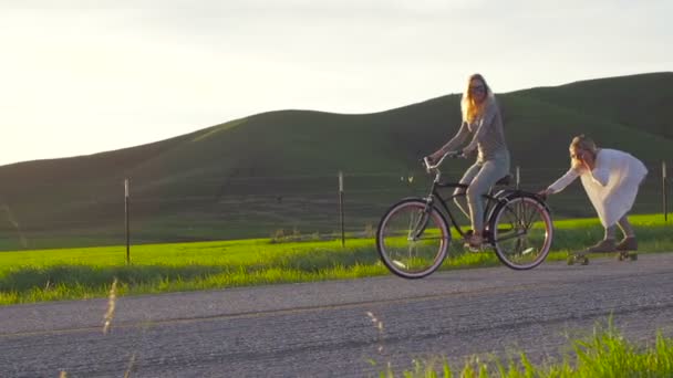 Dos Chicas Jóvenes Felices Riendo Mientras Montan Bicicleta Atardecer Cámara — Vídeos de Stock