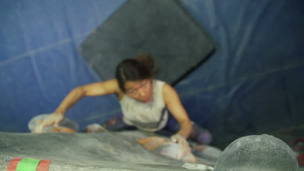 年轻女子攀岩在体育馆内 — 图库视频影像