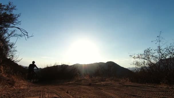 Slow Motion Silhouette Hombre bicicleta de montaña al atardecer fuera — Vídeos de Stock