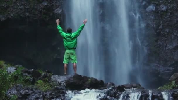 Člověk dělá úspěch pozice vně před vodopád — Stock video