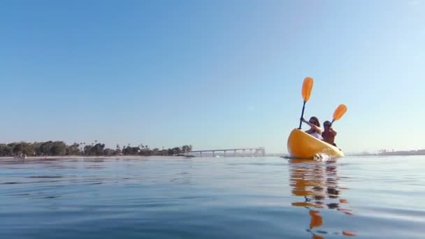 Молодая счастливая пара плавает на байдарках в океане — стоковое видео