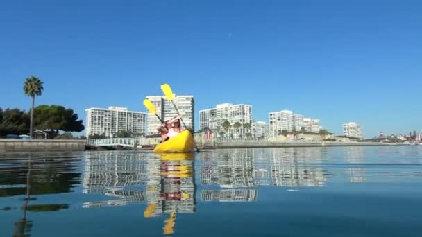 Jonge gelukkige paar in oceaan kajakken — Stockvideo