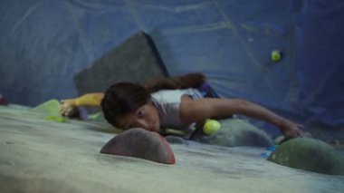 Genç kadın dağcılık içinde spor salonunda 