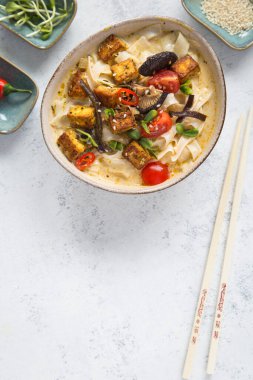 Sebzeli Tayland baharatlı çorba, tofu, hindistan cevizi sütü, limon yaprağı, kırmızı biber ve galangal kökü tozu. Vejetaryen, sağlıklı yemek, glütensiz. Beyaz arkaplan, üst görünüm, kopyalama alanı.