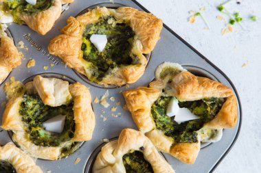 Hafif arka planda ıspanaklı ve peynirli puf böreği. Üst görünüm.