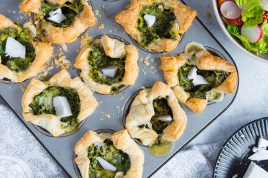 Hafif arka planda ıspanaklı ve peynirli puf böreği. Üst görünüm.