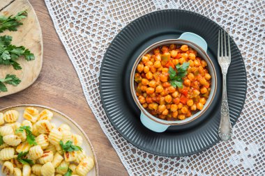 Ahşap arka planda kırmızı ve yeşil dolmalık biberli nohut yahnisi. Sağlıklı vejetaryen gıda konsepti. Yüksek proteinli yemek, kırmızı biber.. 