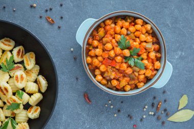 Kırmızı ve yeşil dolmalık biberli nohut yahnisi, gri arka plan, üst manzara. Sağlıklı vejetaryen gıda konsepti. Yüksek proteinli yemek, kırmızı biber.. 