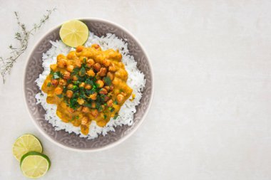 Hint vejetaryen chana masala. Baharatlı nohut körisi, maydanozlu domates sosu, tabakta pilav ile servis edilir..